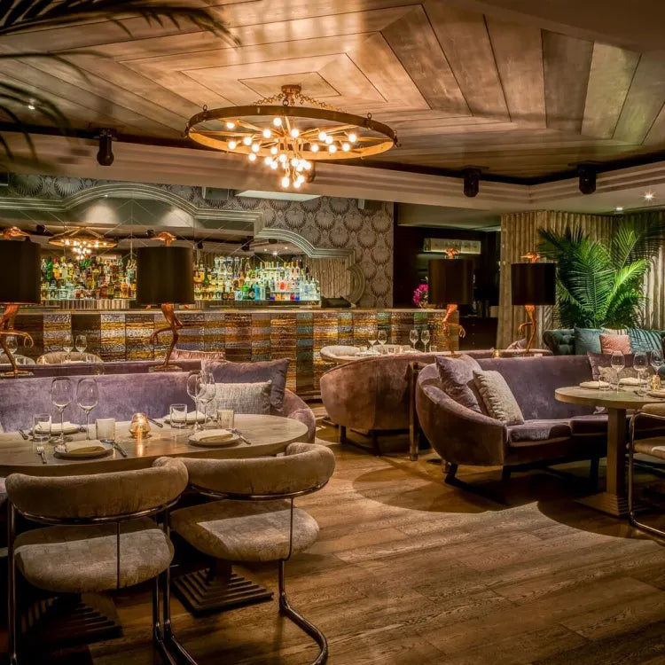 Byblos, Miami: well-stocked bar with a curved counter, dark wood paneling, and hanging lights.