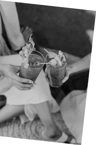 Black and white picture of two people clinking glasses of Axia Spirit Bloody Medusa