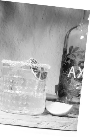 Black and white picture of Axia Spirit Margarita Cocktail next to a bottle and a lemon slice