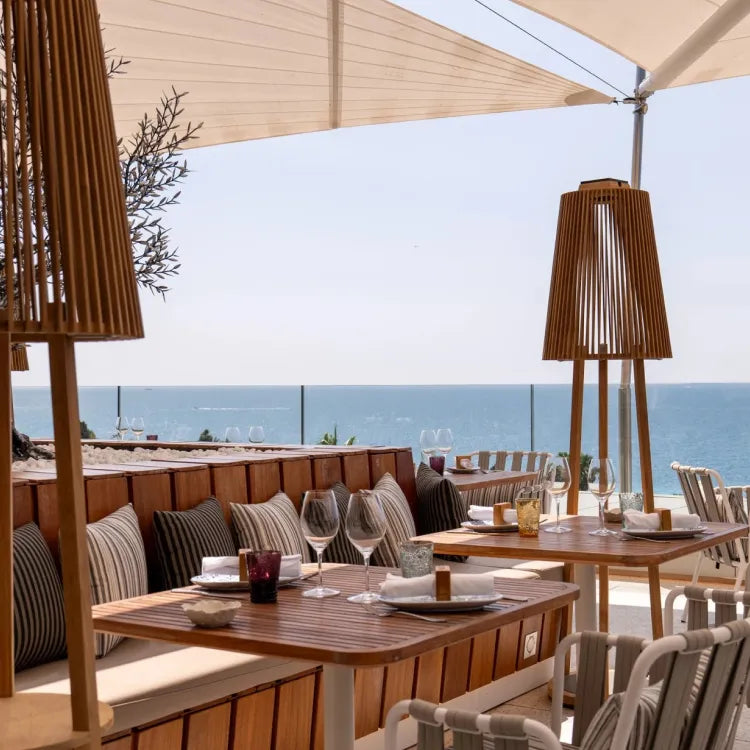 Maison Albar Le Victoria Rooftop, Nice: chic outdoor restaurant patio with wooden tables and benches, overlooking the sea