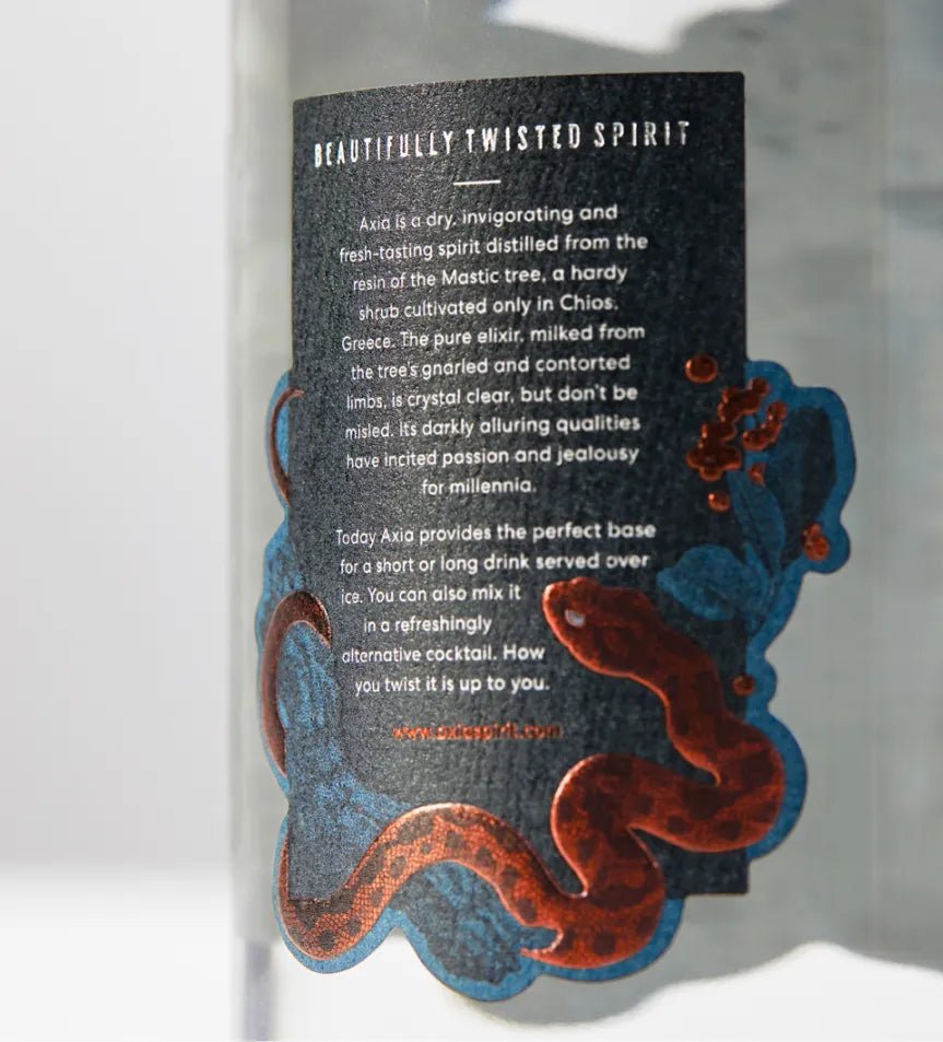Close-up of the bottle label of Axia Mastiha Spirit on a plain light grey background