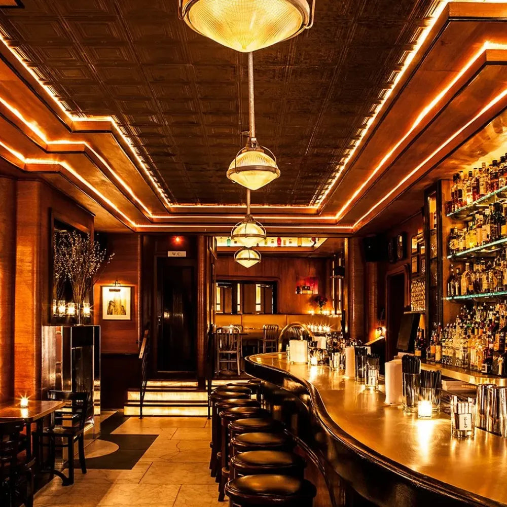 Employees Only, New York: cozy, dimly lit bar with curved counter and warm, ambient lighting