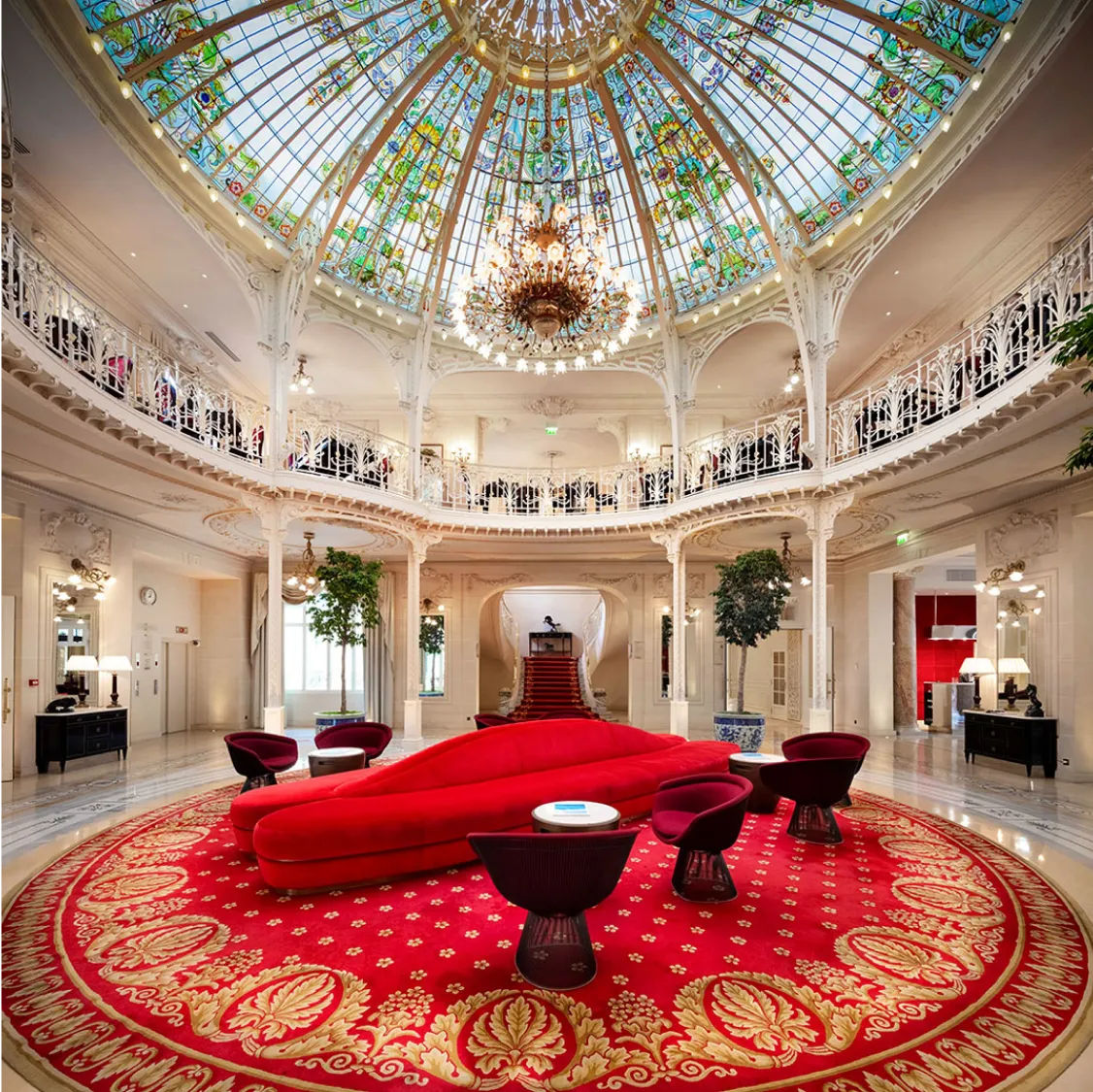 Hotel Hermitage, Monaco: Elegant hotel lobby with red seating under a stained-glass dome