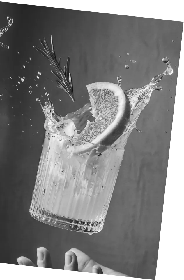 Black and white picture of an Axia Greek Mastiha Spirit Aegean Paloma Cocktail with grapefruit slice and rosemary garnish