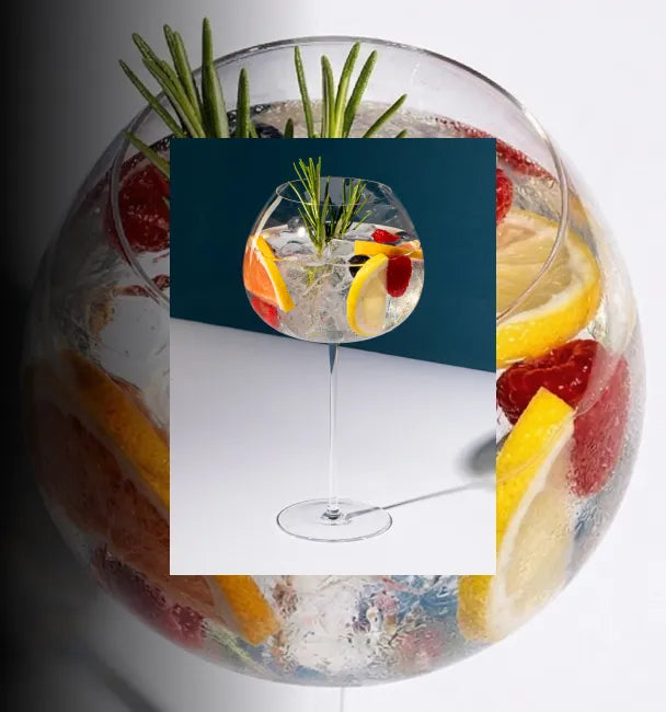 Axia Greek Mastiha Spirit Tonic Cocktail garnished with lemon slices, raspberries, and rosemary on a dark blue background with a secondary picture in the background of another Tonic coktail