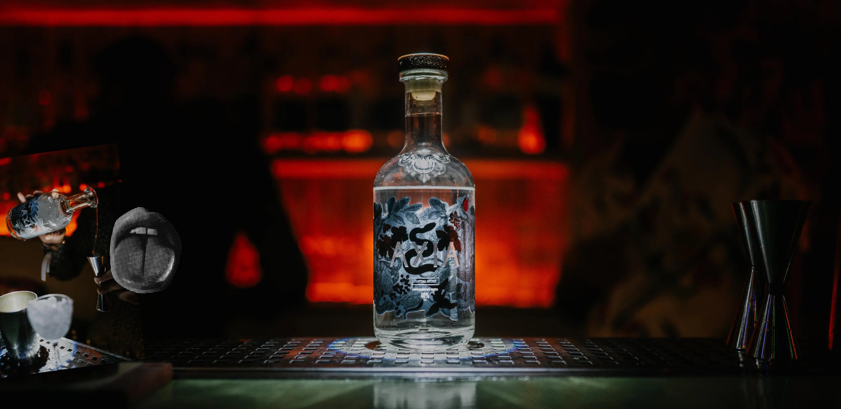 Bottle of Axia Spirit on a bar in the dark with red light in the background and a black and white opened mouth picture on the left next to someone pouring Axia Spirit