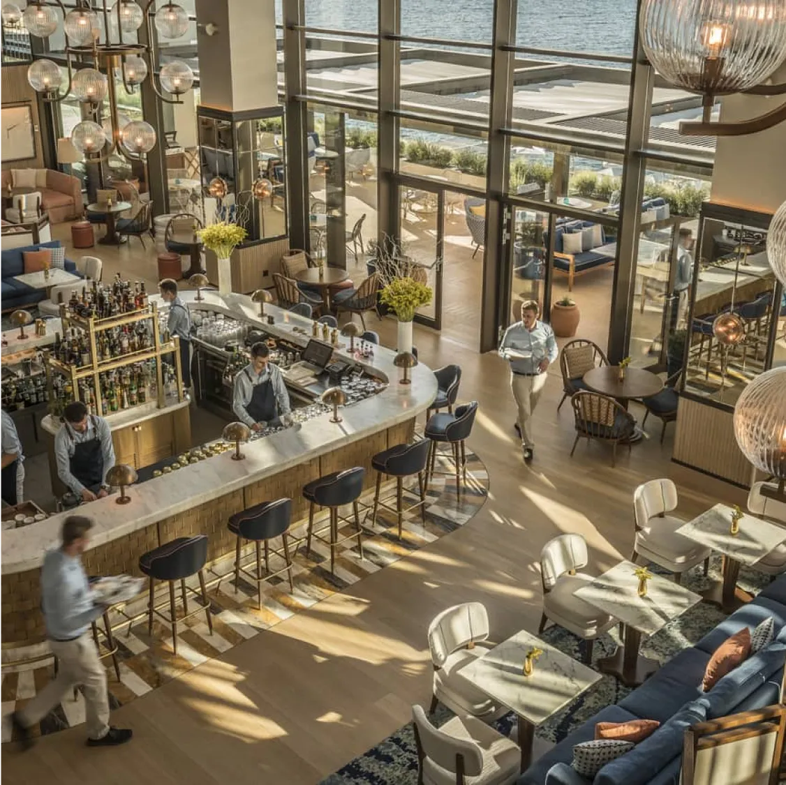 Four Seasons Astir Palace Hotel, Athens: Bright, modern restaurant with bar, tables, and water view.