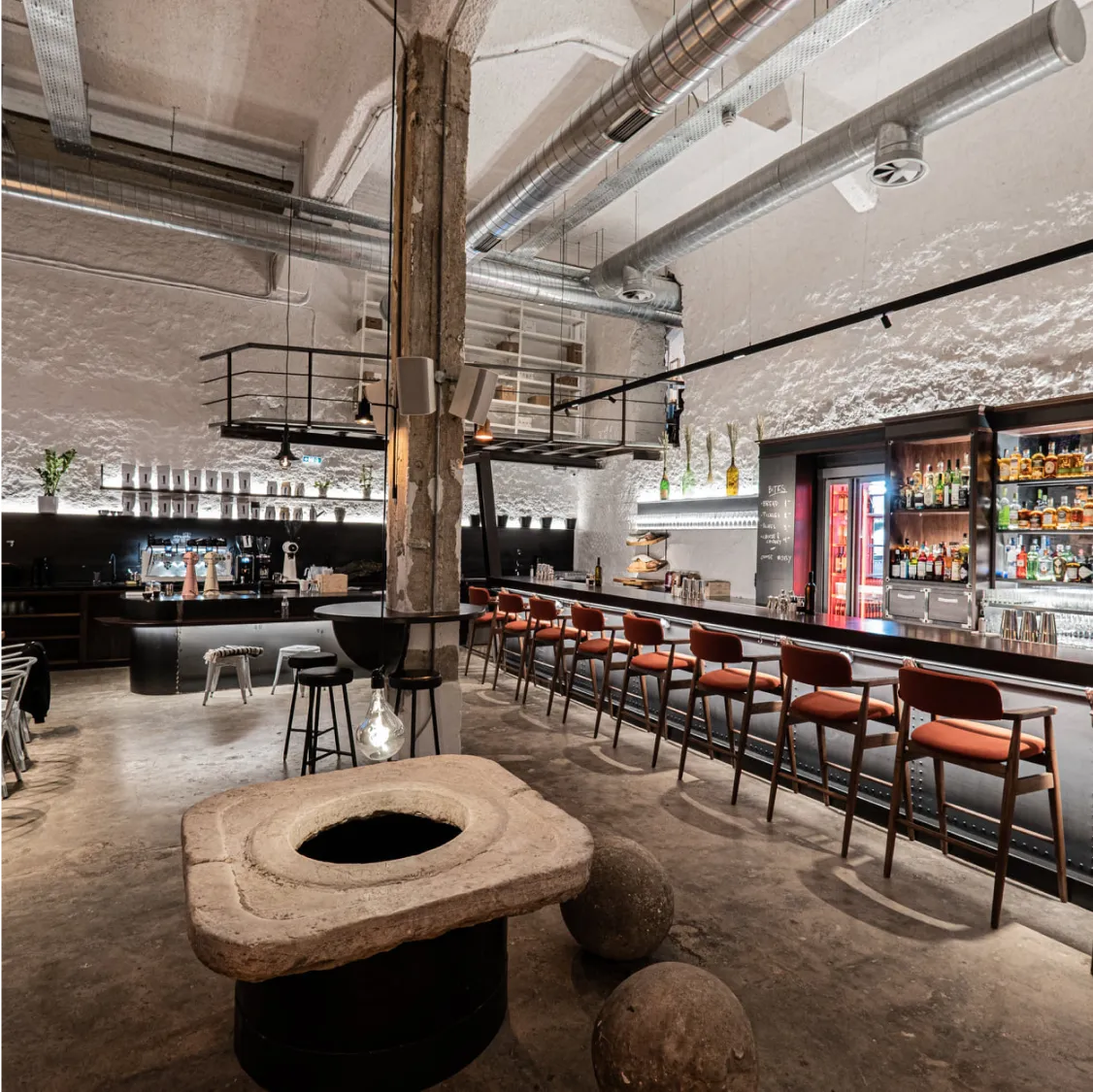 Line, Athens: Modern industrial bar with unique stone table and seating.