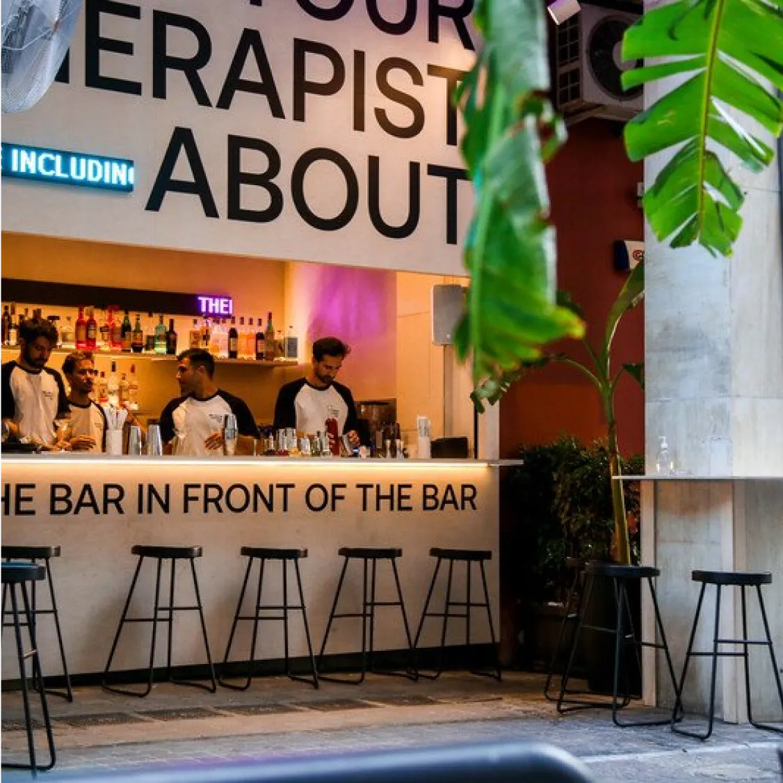 The Bar in Front of The Bar, Athens: Outdoor bar area with stools and bartenders working.